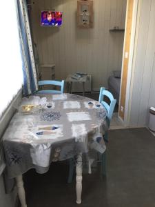una mesa en una habitación con mesa y sillas en Petite maison dans le jardin en Ars-en-Ré