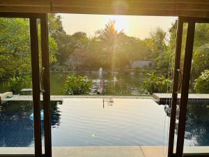 Pool Villas by Honey-5 miles from central Pattaya Beach في Nong Prue: إطلالة المسبح من خلال باب زجاجي منزلق