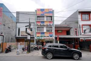 a black car parked in front of a building at RedDoorz at Buah Batu 5 in Bandung