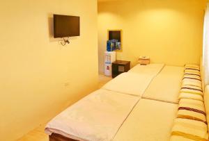 um quarto com uma cama e uma televisão na parede em RedDoorz @ Jackie’s Hotel & Restaurant em Ipil