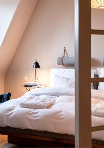 a bedroom with a bed with white sheets at The Duxiana Malmö in Malmö
