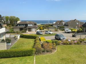 arial view of a house with cars parked in a parking lot at Haus Humml in Grömitz