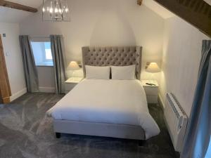 een slaapkamer met een groot wit bed en 2 lampen bij Woodlands Hall Hotel in Ederyn
