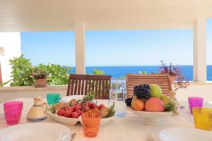 un tavolo con ciotole di frutta sopra di Dimora degli Artisti - Ciolo private sea access a Gagliano del Capo