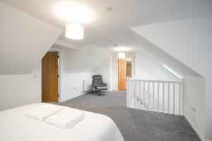 - une chambre blanche avec un lit et un escalier dans l'établissement South Esk Apartment 7, à Montrose
