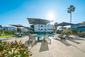 a group of chairs and umbrellas next to a pool at The Palmiers in Paphos