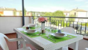 uma mesa branca com um vaso de flores numa varanda em R18 Residence Adamo e Eva nuovo bilocale em Marcelli
