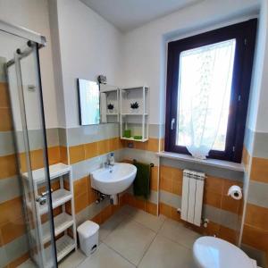 uma casa de banho com um lavatório, um WC e uma janela. em R18 Residence Adamo e Eva nuovo bilocale em Marcelli