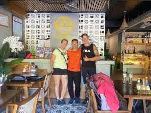 three people posing for a picture in a restaurant at Quiri Hotel in Cat Ba