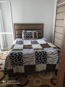 Una cama con edredón en un dormitorio en طريق أشقار العرفان 3 en Tánger