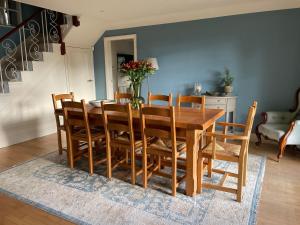 a dining room with a wooden table and chairs at Appletree Cottage in Heswall