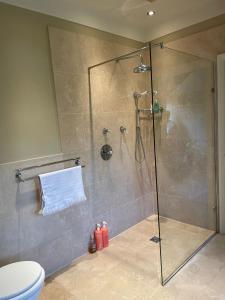 a bathroom with a shower with a glass door at Appletree Cottage in Heswall