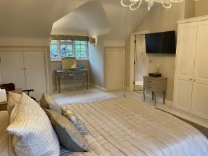 a bedroom with a bed and a desk and a window at Appletree Cottage in Heswall