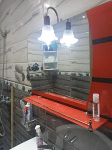 un espejo sobre un fregadero con dos luces encima en طريق أشقار العرفان 3 en Tánger
