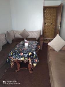 sala de estar con mesa y sofá en طريق أشقار العرفان 3 en Tánger