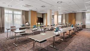 une salle de conférence avec des tables et des chaises dans un bâtiment dans l'établissement Styles Hotel Karlsruhe Messe, à Karlsruhe