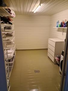 une chambre vide avec un réfrigérateur et une étagère dans l'établissement Feriehus ved Saltstraumen, à Bodø