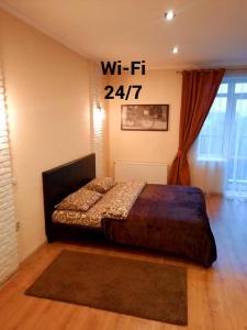 a bedroom with a bed with a sign on the wall at Квартири подобово Івано-Франківська Nice apartments for booking in Ivano-Frankivsʼk