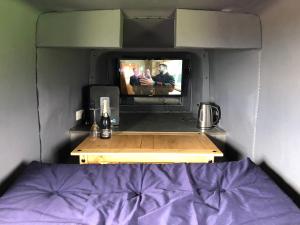 a bedroom with a tv and a bed in a room at Helipod in Boston