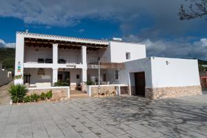 a large white house with a driveway at VILLA ES CUBELLS COUNTRY & SEA in Es Cubells