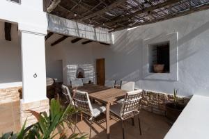 a dining room with a wooden table and chairs at VILLA ES CUBELLS COUNTRY & SEA in Es Cubells