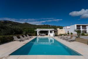 a swimming pool with chairs and a gazebo at VILLA ES CUBELLS COUNTRY & SEA in Es Cubells