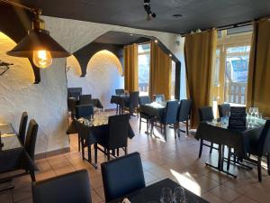 a restaurant with tables and chairs in a room at Hôtel Le Savoie in Albertville