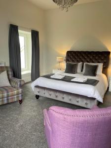 a bedroom with a large bed and a couch at Woodlands Hall Hotel in Ederyn
