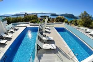einen Pool mit Liegestühlen neben einem Resort in der Unterkunft Diamond Blue Villas Lefkada in Nydri