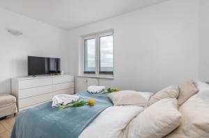 Biały salon z kanapą i telewizorem w obiekcie Apartament przy Plaży - Campingowa - Widok na Morze by Noclegi Renters w mieście Międzyzdroje