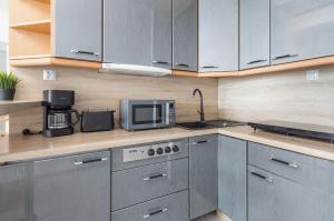 a kitchen with stainless steel cabinets and a microwave at Beachfront Apartment Campingowa by Renters in Międzyzdroje