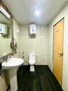 a bathroom with a white toilet and a sink at Lacasa Luxury Stays in Shogi