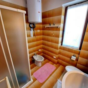 a bathroom with a shower and a toilet and a sink at Appartamento Monte Muggio - Your Mountain Holiday in Casargo