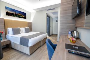 una camera d'albergo con letto e TV di The Omiya Hotel a Istanbul