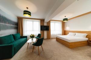 una camera d'albergo con letto e divano di Hotel Küküllő - Târnava a Odorheiu Secuiesc