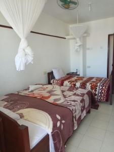 two beds in a white room with two beds sidx sidx sidx at Golden Guest House- Miritini in Mombasa