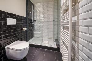uma casa de banho com um chuveiro e um WC. em NYCE Hotel Dortmund Thier Galerie em Dortmund