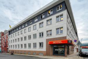 a large white building with a red sign on it at NYCE Hotel Dortmund Thier Galerie in Dortmund