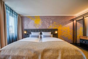 1 dormitorio con 1 cama grande con almohadas blancas en NYCE Hotel Dortmund Thier Galerie en Dortmund