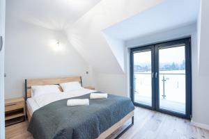 1 dormitorio con cama y ventana grande en Domki Słoneczna 11 z widokiem na Śnieżkę, en Karpacz