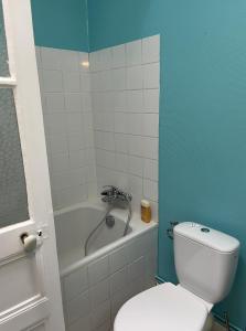 a bathroom with a white toilet and a bath tub at Appartement au centre de Dinard in Dinard