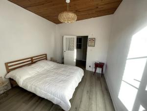 a bedroom with a white bed and a wooden floor at Appartement au centre de Dinard in Dinard