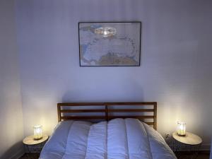 ein Schlafzimmer mit einem Bett mit zwei Nachttischen mit Beleuchtung in der Unterkunft Appartement au centre de Dinard in Dinard