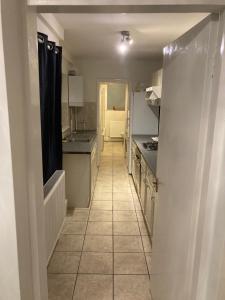 a kitchen with a hallway leading to a kitchen with appliances at Lovely 2 Bed House Apartment in Boston TownCentre in Boston