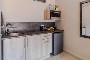 a kitchen with a sink and a microwave at Guest On Wynne in Centurion