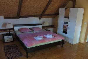 a bedroom with a bed with pink sheets and a mirror at Pension U Starýho Dubu in Jindřichŭv Hradec