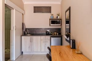 a kitchen with a wooden table in a room at Guest On Wynne in Centurion