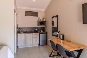 a kitchen and dining room with a wooden table and chairs at Guest On Wynne in Centurion
