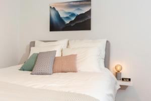 a bedroom with a white bed with a picture on the wall at City Center Family Apartment Balcony open View Delft in Delft