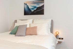 - une chambre dotée d'un lit blanc avec une photo sur le mur dans l'établissement Charming Retreat Cozy Family Apartment-20B, à Delft